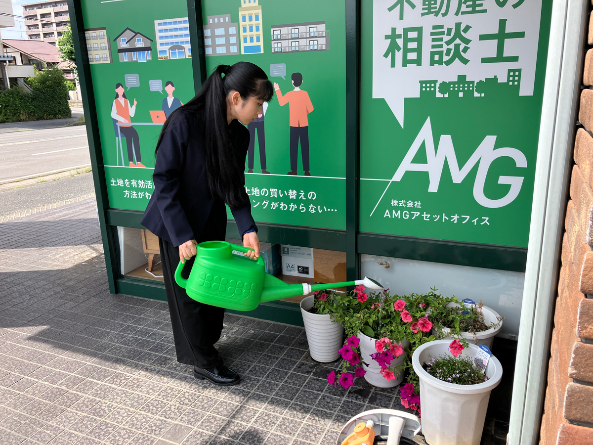 オフィス前でお花に水をやるスタッフ