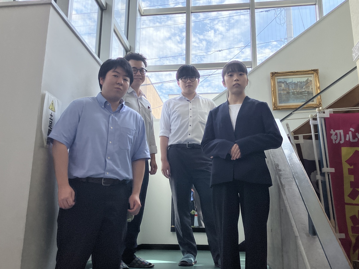 光が差し込む吹き抜け階段での集合写真